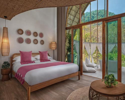 een slaapkamer met een bed en een groot raam bij ภูคานาน่าน รีสอร์ท 