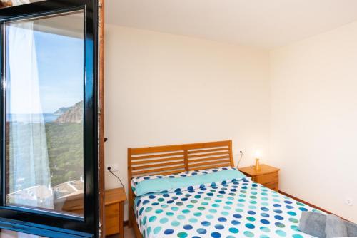 um quarto com uma cama e uma grande janela em Amazing Seaview house in Tamariu em Girona