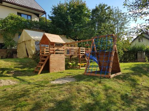 a wooden play set in a yard with a playground at Noclegi MAJA in Solina