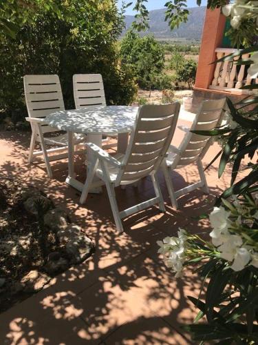 drie stoelen en een tafel en een tafel en stoelen bij Villa Vida in Úbeda