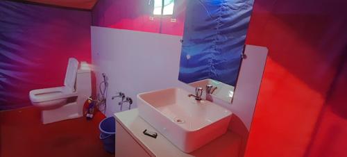 a red and white bathroom with a sink and a toilet at P3 Camp Pangong in Spangmik
