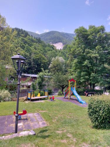 a park with playground equipment and a light pole at La petite rose in Limone Piemonte