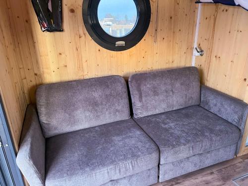 a couch sitting in a room with a window at Hausboot JAWE auf der Kleinseenplatte in Kleinzerlang