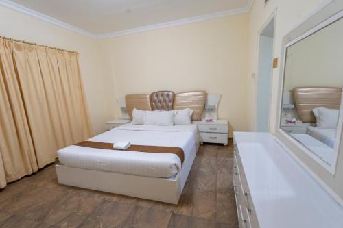 a bedroom with a bed and a large mirror at Majestic Hotel in Manama