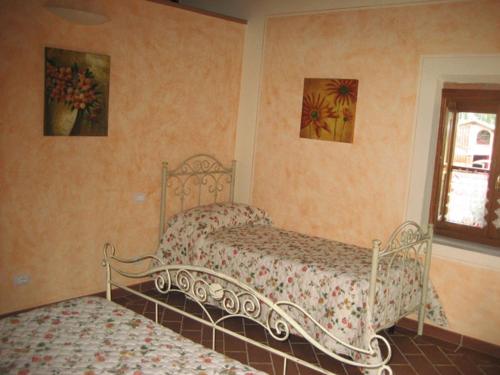 a bedroom with two beds and a window at La Vallata - Lajatico Azienda Naturalistica Agriturismo in Laiatico