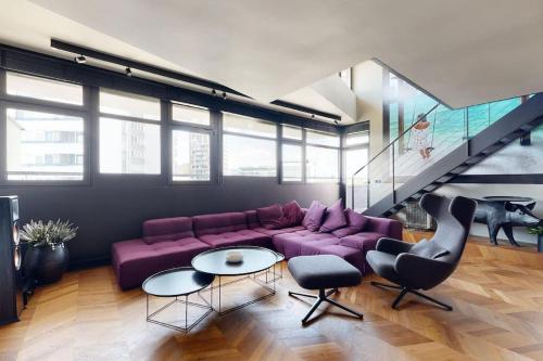 a living room with a purple couch and a table at Štýlový loft s ohromnou terasou in Bratislava