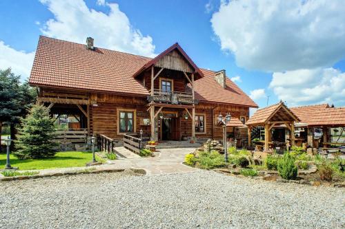 a log cabin with a porch and a balcony at Zajazd Sanocki in Sanok