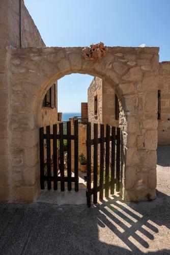 an entrance to a stone building with a gate at The Stonemade Houses in Falasarna