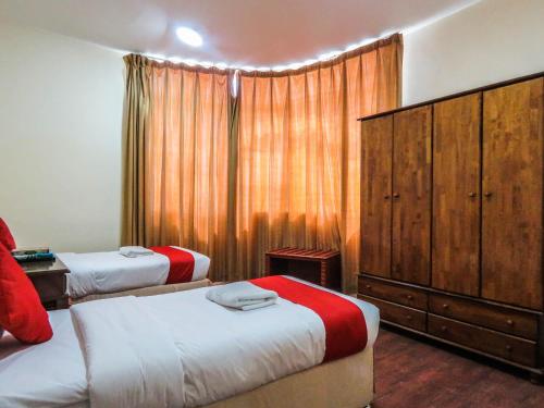 a bedroom with two beds and a large window at Al Ferdous Hotel Apartment in Sharjah