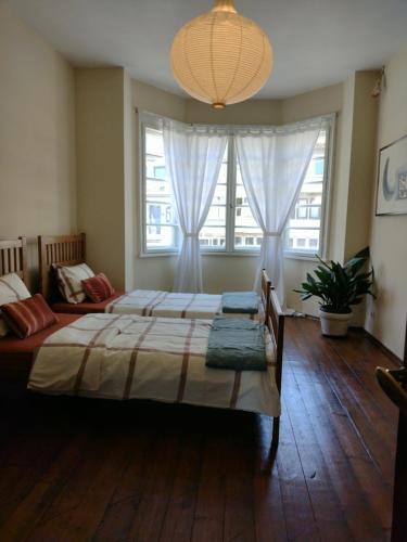 a bedroom with two beds and a large window at Art Studio Turnovo in Veliko Tŭrnovo