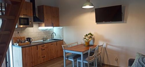 a small kitchen with a table and chairs and a tv at Piękne Zielone in Zator