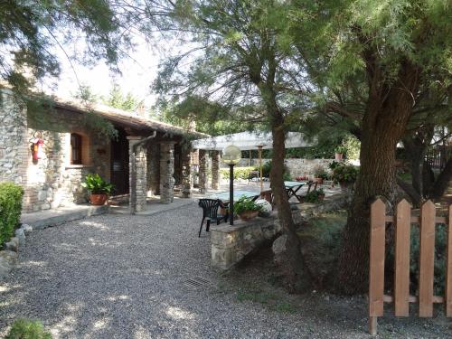 una casa con un albero, una panchina e una recinzione di Agriturismo Bandinacci a Santa Luce