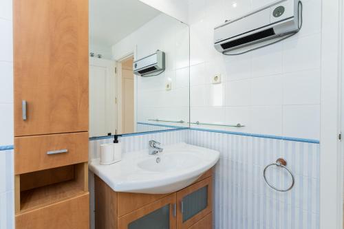ein Bad mit einem Waschbecken und einem Spiegel in der Unterkunft BLONZU SUDÁFRiCA in Benalmádena