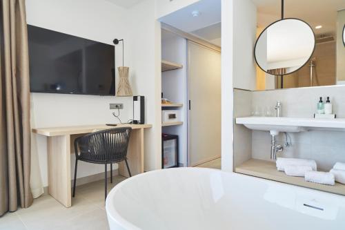 a white bathroom with a sink and a mirror at Invisa Hotel Club Cala Verde in Es Figueral Beach