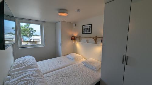 a bedroom with a bed and a window at Dragsö Camping & Stugby in Karlskrona