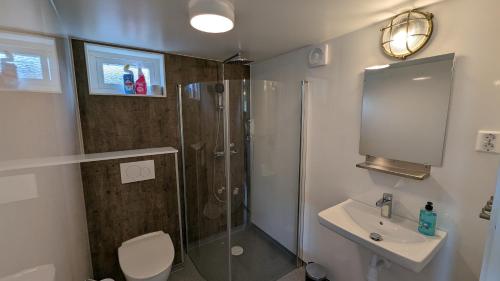 a bathroom with a shower and a toilet and a sink at Dragsö Camping & Stugby in Karlskrona