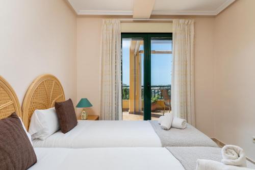 two beds in a bedroom with a view of a balcony at BLONZU SUDÁFRiCA in Benalmádena
