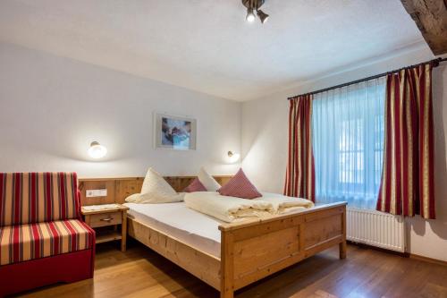 a bedroom with a bed and a desk and a window at Mitterbruggehof Apt Alpenrose in Anterselva di Mezzo