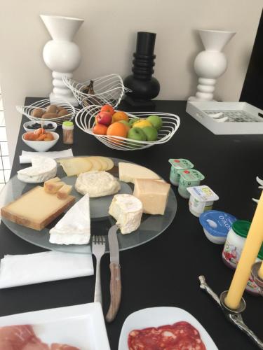 a table with a plate of cheese and other foods at Villa Tiffany in Braine-lʼAlleud