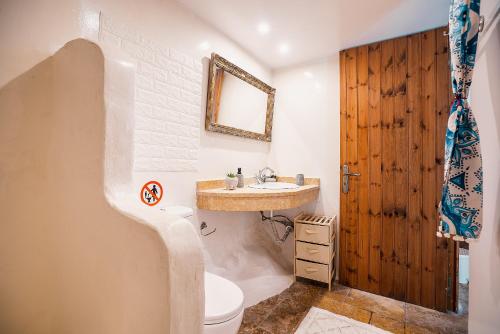 a bathroom with a sink and a toilet and a mirror at Fedra's Traditional House in Psinthos