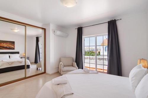 1 dormitorio con cama y ventana grande en Sol da Bornacha, en Vila Nova de Cacela