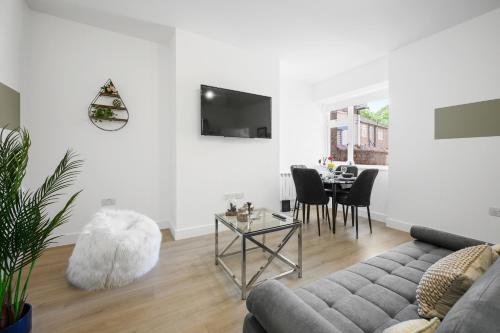 a living room with a couch and a table at Ideal Lodgings In Urmston in Urmston