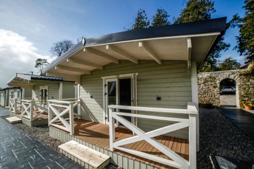 a small house with a porch and a wooden deck at Springfort Hall Hotel in Mallow