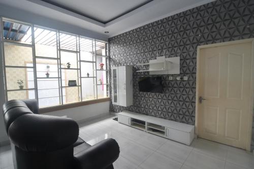 uma sala de estar com uma cadeira e uma porta em OYO 92714 Miracle Kost em Manado