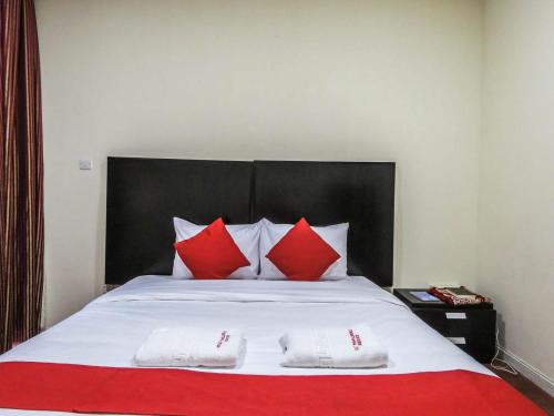 a bed with red and white pillows on it at Al Ferdous Hotel Apartment in Sharjah
