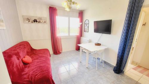 un salon avec un canapé rouge et une table dans l'établissement Les Vagues Douces - Base Nautique Plage Pied, à Saint-Jean-de-Monts