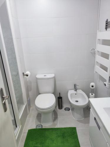 a white bathroom with a toilet and a sink at Vista Panorâmica Amadora in Amadora