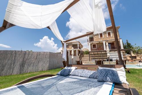 a bed in the yard of a house at Armonia Seaside Villas in Vasilikos