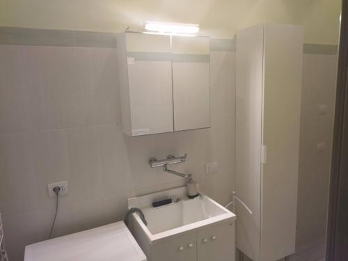 a white bathroom with a sink and a cabinet at Room in Guest room - Double room between Padua and Chioggia in Brugine