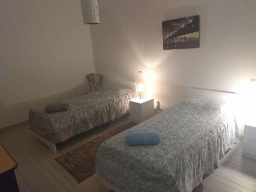 a bedroom with two beds and a table with a lamp at Room in Guest room - Double room between Padua and Chioggia in Brugine