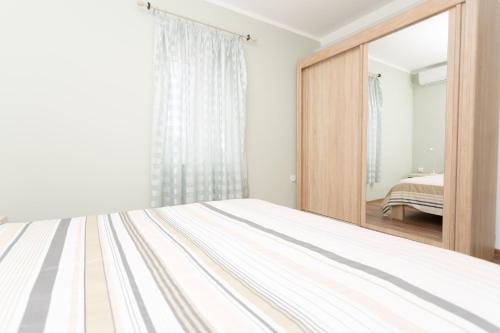a bedroom with a bed and a mirror at apartman 2 in Budva
