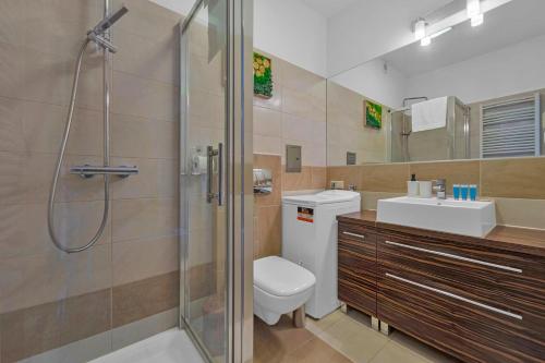a bathroom with a shower and a toilet and a sink at Rynek Nowego Miasta Two-Level Apartment by BookingHost in Warsaw