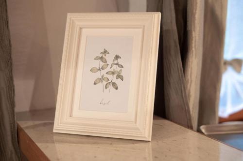 a picture in a white frame on a table at Country house At Peskar`s in Podbrdo