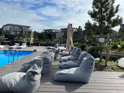 a row of inflatable tubes next to a swimming pool at Modern & cozy studio with patio “Prie Juros” in Palanga