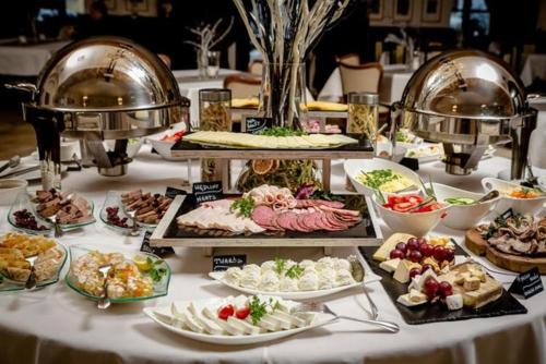 uma mesa com muitos tipos diferentes de alimentos sobre ele em Hotel Zamkowy em Wałbrzych