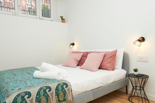 a bedroom with a bed with pink and white pillows at MILANO URBAN FLATS Modern apartments few minuts from Duomo in Milan