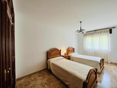 1 Schlafzimmer mit 2 Betten und einem Fenster in der Unterkunft Gran apartamento completo con terraza en O Barqueiro in O Barqueiro