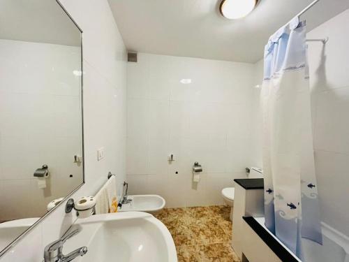ein weißes Badezimmer mit einem Waschbecken und einem Spiegel in der Unterkunft Gran apartamento completo con terraza en O Barqueiro in O Barqueiro