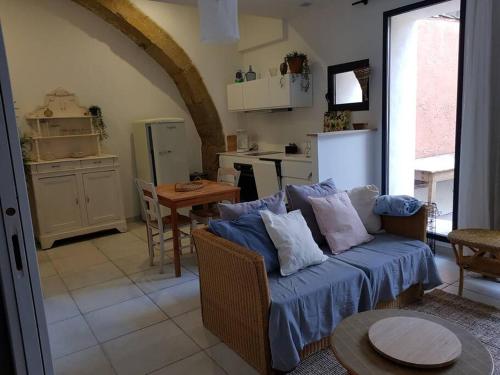un salon avec un canapé et une cuisine dans l'établissement Appartement T2 avec jardin privatif 3 étoiles, à Mèze