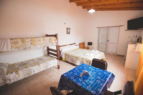Habitación con 2 camas, mesa y sofá en Los Abuelos en General Pico