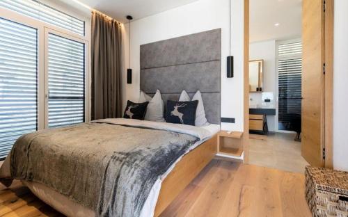 Luxus Design Chalet Sonnrain في بيسندورف: غرفة نوم بسرير كبير مع اللوح الأمامي كبير