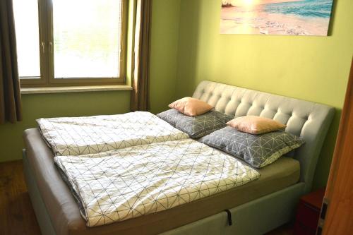 ein Bett mit zwei Kissen auf einem Zimmer in der Unterkunft Kaskády, Veľký Krtíš in Veľký Krtíš