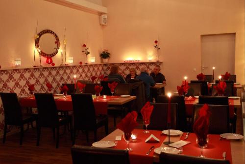 a restaurant with people sitting at tables in a room at Hotel zur Heideblüte in Hambühren