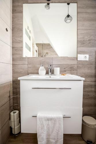 a white bathroom with a sink and a mirror at Apartamenty Dwupoziomowe Na Dwa Widoki z Jacuzzi & Sauna in Zakopane