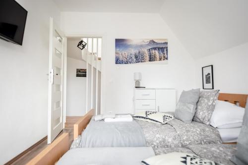 a living room with a bed and a couch at Apartamenty Dwupoziomowe Na Dwa Widoki z Jacuzzi & Sauna in Zakopane