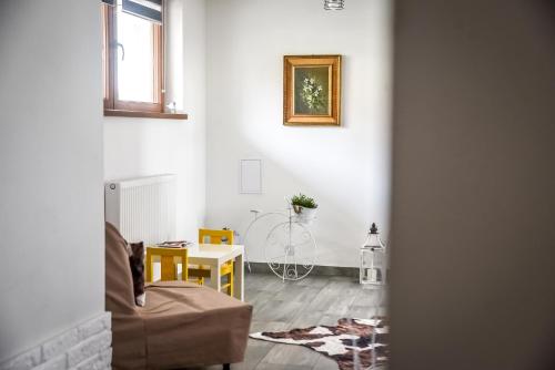 a living room with a couch and a table at Apartamenty Dwupoziomowe Na Dwa Widoki z Jacuzzi & Sauna in Zakopane